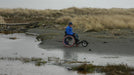 Freewheel Wheelchair Attachment user next to river in sand